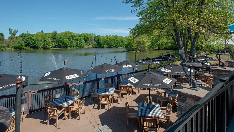 Outdoor dining area with tables and umbrellas with view of the water